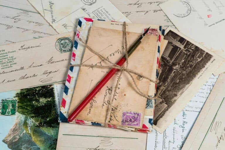 Vintage letters and postcards with a red pen and string, nostalgic correspondence scene.